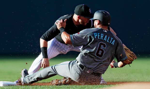 Arizona Diamondbacks' David Peralta, front, slides safely into second base as he advances on a sacr...