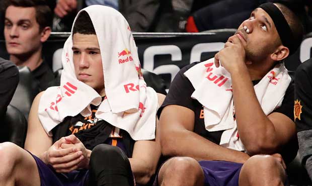Phoenix Suns' Alex Len, left, Devin Booker, center, and Jared Dudley watch their teammates play dur...