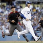 Arizona Diamondbacks third baseman Jake Lamb, left, tags out Los Angeles Dodgers' Yasmani Grandal between second and third attempting to advance on a ball hit by Logan Forsythe during the second inning of a baseball game in Los Angeles, Wednesday, July 5, 2017. (AP Photo/Alex Gallardo)