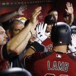 Arizona Diamondbacks' Jake Lamb, right, is congratulated by teammates, including A.J. Pollock, left, after Lamb's sacrifice fly against the Atlanta Braves during the first inning of a baseball game Wednesday, July 26, 2017, in Phoenix. (AP Photo/Ross D. Franklin)