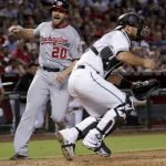 Washington Nationals' Daniel Murphy (20) scores on a base hit by  Wilmer Difo as Arizona Diamondbacks catcher Jeff Mathis waits for the throw during the sixth inning of a baseball game, Friday, July 21, 2017, in Phoenix. (AP Photo/Matt York)