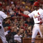 St. Louis Cardinals' Tommy Pham (28) is congratulated by teammate Yadier Molina after scoring during the sixth inning of a baseball game against the Arizona Diamondbacks Friday, July 28, 2017, in St. Louis. (AP Photo/Jeff Roberson)