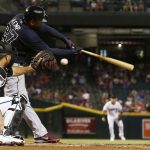 Atlanta Braves' Matt Kemp (27) strikes out as Arizona Diamondbacks' Chris Iannetta, left, reaches out for the ball during the first inning of a baseball game Tuesday, July 25, 2017, in Phoenix. (AP Photo/Ross D. Franklin)