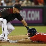 Washington Nationals' Chris Heisey, right, dives safely into third base with a triple as Arizona Diamondbacks' Jake Lamb, left, applies a late tag during the sixth inning of a baseball game Saturday, July 22, 2017, in Phoenix. (AP Photo/Ross D. Franklin)