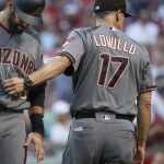 Arizona Diamondbacks manager Torey Lovullo (17) takes right fielder J.D. Martinez, left, out of the game after Martinez was struck while swinging at a pitch from Cincinnati Reds starting pitcher Tim Adleman in the fourth inning of a baseball game, Wednesday, July 19, 2017, in Cincinnati. (AP Photo/John Minchillo)