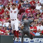 Cincinnati Reds first baseman Joey Votto (19) leaps from the bag to catch a wild throw that allows Arizona Diamondbacks' A.J. Pollock to reach first in the third inning of a baseball game, Wednesday, July 19, 2017, in Cincinnati. (AP Photo/John Minchillo)