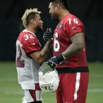 Arizona Cardinals free safety Tyrann Mathieu (32) and guard Mike Iupati (76) greet each other during the first day of NFL football training camp for the team, Saturday, July 22, 2017, in Glendale, Ariz. (AP Photo/Matt York)