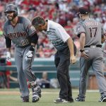 Arizona Diamondbacks' J.D. Martinez (28) winces in pain alongside manager Torey Lovullo (17), and a trainer, center, after being struck while swinging at a pitch from Cincinnati Reds starting pitcher Tim Adleman in the fourth inning of a baseball game, Wednesday, July 19, 2017, in Cincinnati. (AP Photo/John Minchillo)