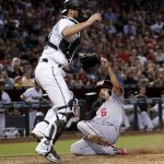 Washington Nationals' Anthony Rendon (6) scores on a ground out by Wilmer Difo as Arizona Diamondbacks catcher Jeff Mathis stands near the plate during the eighth inning of a baseball game, Friday, July 21, 2017, in Phoenix. (AP Photo/Matt York)