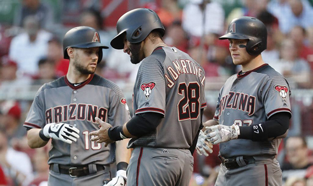 Arizona Diamondbacks' J.D. Martinez (28), center, winces in pain after after he was struck while sw...