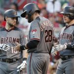 Arizona Diamondbacks' J.D. Martinez (28), center, winces in pain after after he was struck while swinging at a pitch from Cincinnati Reds starting pitcher Tim Adleman and taken out of the game in the fourth inning of a baseball game, Wednesday, July 19, 2017, in Cincinnati. (AP Photo/John Minchillo)