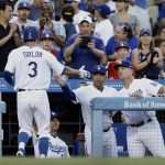 Los Angeles Dodgers' Chris Taylor (3) gets congratulations from manager Dave Roberts, center, and bench coach Bob Geren, right, for scoring on an RBI double by Yasmani Grandal during the second inning against the Arizona Diamondbacks in a baseball game in Los Angeles, Wednesday, July 5, 2017. (AP Photo/Alex Gallardo)