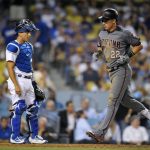 Arizona Diamondbacks' Jake Lamb, right, scores on his solo home run as Los Angeles Dodgers catcher Austin Barnes watches during the fifth inning of a baseball game, Thursday, July 6, 2017, in Los Angeles. (AP Photo/Mark J. Terrill)