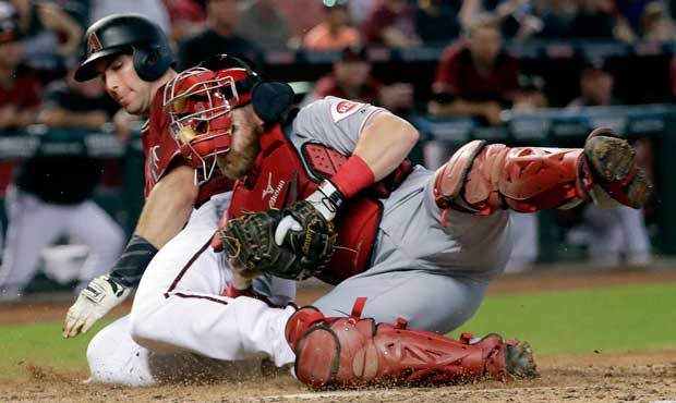Arizona Diamondbacks' Paul Goldschmidt is tagged out at the plate by Cincinnati Reds catcher Tucker...