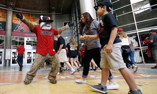 Arizona Diamondbacks mascot Baxter, left, greets fans as they arrive at Chase Field prior to an Ope...