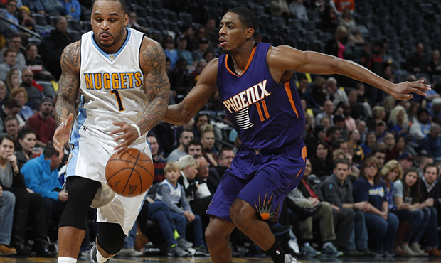 Denver Nuggets guard Jameer Nelson, left, pursues a loose ball with Phoenix Suns guard Brandon Knig...