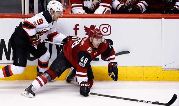 Arizona Coyotes left wing Jordan Martinook (48) falls to the ice as he tries to keep the puck away ...