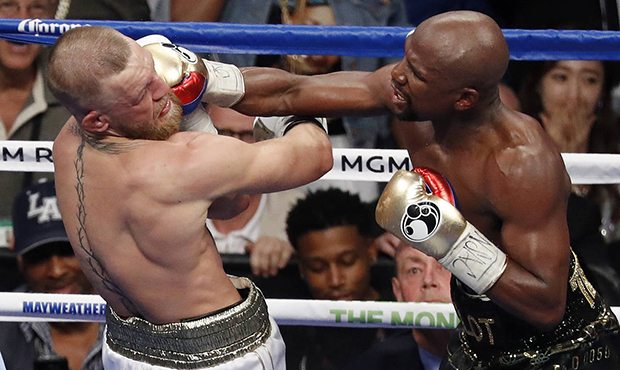 Floyd Mayweather Jr. hits Conor McGregor in a super welterweight boxing match Saturday, Aug. 26, 20...