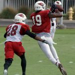 Receiver Carlton Agudosi tries to make a catch in front of Justin Bethel during a training camp practice Aug. 1. (Photo by Adam Green/Arizona Sports)