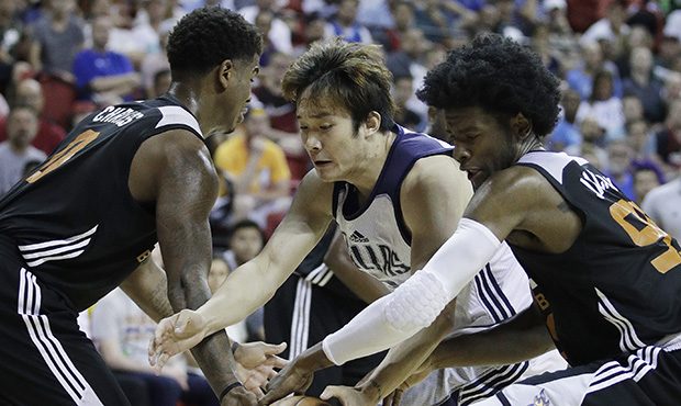 Dallas Mavericks' Ding Yanyuhang, center, battles for the ball with Phoenix Suns' Marquese Chriss, ...