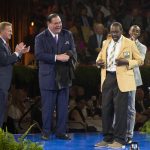 NFL Commissioner Roger Goodell, left, and David Baker, president of the Pro Football Hall of Fame, applaud as Kenny Easley receives his gold jacket from his son Kendrick Easley at the Pro Football Hall of Fame enshrinees' dinner, Friday, Aug. 4, 2017, in Canton, Ohio. (Bob Rossiter/The Canton Repository via AP)