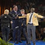 NFL Commissioner Roger Goodell, left, and David Baker, president of the Pro Football Hall of Fame, applaud as Terrell Davis receives his gold jacket from his presenter, Neil Schwartz, at the Pro Football Hall of Fame enshrinees' dinner, Friday, Aug. 4, 2017, in Canton, Ohio. (Bob Rossiter/The Canton Repository via AP)