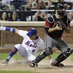 New York Mets' Brandon Nimmo (9) slides past Arizona Diamondbacks catcher Chris Iannetta to score on a single by Michael Conforto during the fifth inning of a baseball game Wednesday, Aug. 23, 2017, in New York. (AP Photo/Frank Franklin II)
