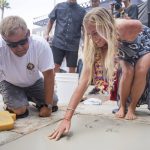 Bethany Hamilton leaves her handprint in the concrete in front of Huntington Surf and Sport as part of her induction into the Surfers' Hall of Fame in Huntington Beach, Calif., Friday, Aug. 4, 2017. The surfer was bitten by a shark in 2003. (Nick Agro/The Orange County Register via AP)