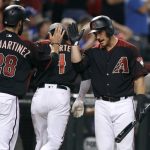 Arizona Diamondbacks' Jeff Mathis, right, congratulates teammates J.D. Martinez (28) and Ketel Marte after they scored against the Chicago Cubs during the sixth inning of a baseball game, Saturday, Aug. 12, 2017, in Phoenix. The Diamondbacks defeated the Cubs 6-2. (AP Photo/Ralph Freso)