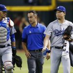 Los Angeles Dodgers' Kenta Maeda, right, of Japan, walks in from the bullpen after warming up with catcher Yasmani Grandal, left, and is joined by interpreter Will Ireton, middle, prior to a baseball game against the Arizona Diamondbacks Thursday, Aug. 31, 2017, in Phoenix. (AP Photo/Ross D. Franklin)