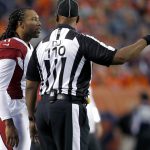 Arizona Cardinals wide receiver Larry Fitzgerald (11) talks with head linesman Phil McKinnely (110) during the first half of an NFL preseason football game against the Denver Broncos, Thursday, Aug. 31, 2017, in Denver. (AP Photo/David Zalubowski)