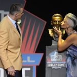 Former NFL quarter Kurt Warner, left, watches as his wife and presenter, Brenda Warner, kisses a bust of him before his speech during inductions at the Pro Football Hall of Fame on Saturday, Aug. 5, 2017, in Canton, Ohio. (AP Photo/David Richard)