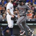 Arizona Diamondbacks' Daniel Descalso (3) crosses the plate to score on his inside-the-park home run, as Houston Astros starting pitcher Mike Fiers, left, looks on during the fourth inning of a baseball game, Thursday, Aug. 17, 2017, in Houston. (AP Photo/Eric Christian Smith)