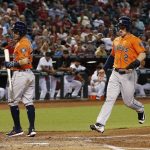 Houston Astros' Alex Bregman (2) scores a run on a wild pitch by Arizona Diamondbacks' Anthony Banda as Astros' Jose Altuve, left, steps out of the way during the second inning of a baseball game Tuesday, Aug. 15, 2017, in Phoenix. (AP Photo/Ross D. Franklin)
