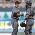 Arizona Diamondbacks pitcher Zack Greinke, left, gets a visit from catcher Jeff Mathis after he gave up the second of two walks to the Minnesota Twins to load the bases during the first inning of a baseball game Saturday, Aug. 19, 2017, in Minneapolis. (AP Photo/Jim Mone)