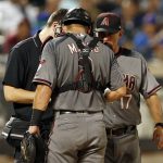 Arizona Diamondbacks catcher Jeff Mathis (2) is checked on by a team trainer and Diamondbacks manager Torey Lovullo (17) during the fourth inning of a baseball game against the New York Mets on Monday, Aug. 21, 2017, in New York. (AP Photo/Adam Hunger)