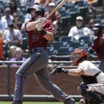 Arizona Diamondbacks' Paul Goldschmidt, left, hits an RBI-double in front of San Francisco Giants catcher Nick Hundley during the first inning of a baseball game in San Francisco, Sunday, Aug. 6, 2017. (AP Photo/Jeff Chiu)