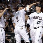 Arizona Diamondbacks' Jake Lamb (22) celebrates with Chris Iannetta (8) and A.J. Pollock (11) after hitting a grand slam during the seventh inning of a baseball game against the Los Angeles Dodgers, Tuesday, Aug. 8, 2017, in Phoenix. (AP Photo/Matt York)