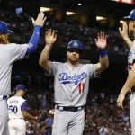 Los Angeles Dodgers' Logan Forsythe (11) celebrates with Justin Turner (10) and Corey Seager, right, after all three scored against the Arizona Diamondbacks on a double by Enrique Hernandez during the first inning of a baseball game Thursday, Aug 10, 2017, in Phoenix. (AP Photo/Ross D. Franklin)