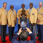 Terrell Davis, center, poses with a bust of himself and former Denver Bronco teammates, from left, John Elway, Willie Brown, Shannon Sharpe, andGary Zimmerman, during inductions at the Pro Football Hall of Fame on Saturday, Aug. 5, 2017, in Canton, Ohio. (AP Photo/Gene J. Puskar)