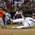 Arizona Diamondbacks' A.J. Pollock (11) scores a run as Houston Astros' Max Stassi, left, chases down a wide throw at home plate during the fifth inning of a baseball game Tuesday, Aug. 15, 2017, in Phoenix. (AP Photo/Ross D. Franklin)