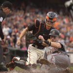 San Francisco Giants catcher Nick Hundley, center, puts the tag on Arizona Diamondbacks' Jake Lamb (22) as he tries to score on J.D. Martinez's double during the first inning of a baseball game Saturday, Aug. 5, 2017, in San Francisco. The umpire is Quinn Wolcott. (AP Photo/D. Ross Cameron)