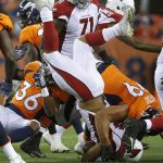 Arizona Cardinals running back Elijhaa Penny is up-ended by Denver Broncos defensive tackle Adam Gotsis, right, and defensive back Orion Stewart (36) during the first half of an NFL preseason football game, Thursday, Aug. 31, 2017, in Denver. (AP Photo/Jack Dempsey)