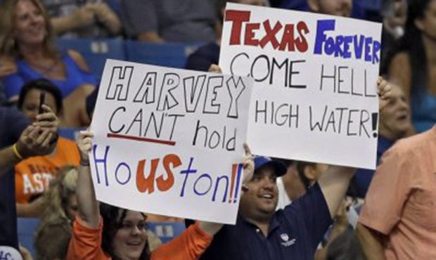 Fans hold up signs as a show of support for the city of Houston during the sixth inning of a baseba...