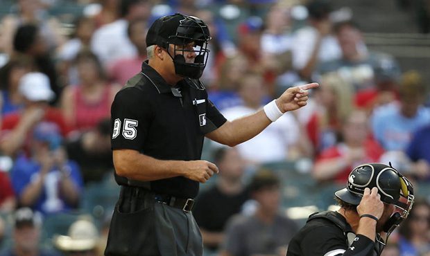 Home plate umpire Tim Timmons (left) signals while Chicago White Sox catcher Kevan Smith, right, ad...