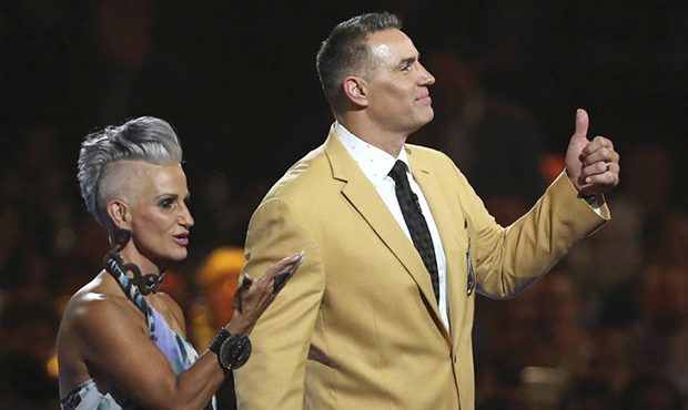 Brenda, left, and Kurt Warner wave to the crowd after Kurt received his gold jacket during the Pro ...