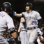 Colorado Rockies' Nolan Arenado (28) yells at a fan after hitting a three-run home run against the Arizona Diamondbacks as Rockies' Gerardo Parra (8) goes to hold Arenado back during the eighth inning of a baseball game Monday, Sept. 11, 2017, in Phoenix. (AP Photo/Ross D. Franklin)