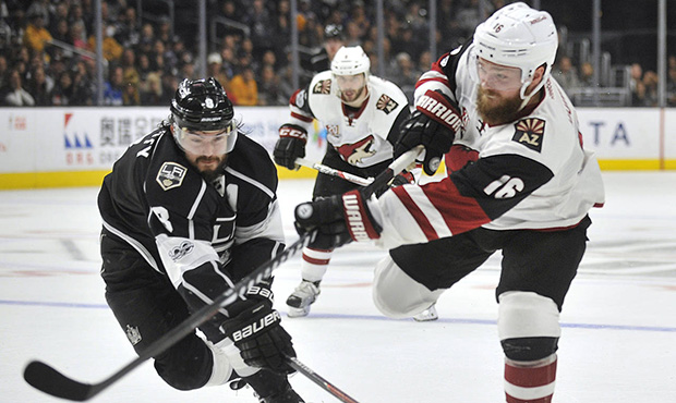 Arizona Coyote left wing Max Domi, right, shoots on goal as Los Angeles Kings defenseman Drew Dough...