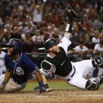 Arizona Diamondbacks' Chris Herrmann, right, shows the umpire the ball in his glove after tagging out San Diego Padres' Manuel Margot, left, as Margot tried to score during the third inning of a baseball game Friday, Sept. 8, 2017, in Phoenix. (AP Photo/Ross D. Franklin)