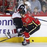 Arizona Coyotes' Mario Kempe, left, from Sweden, struggles to get past Calgary Flames' Dougie Hamilton during the first period of a preseason NHL hockey game, Friday, Sept. 22, 2017 in Calgary, Alberta. (John McIntosh/The Canadian Press via AP)